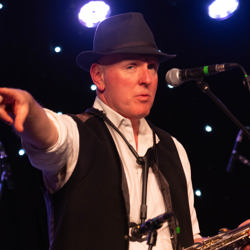 Oly of the Boss and The Beeston Street Band pointing to the crowd before playing hungry heart by Bruce Springsteen.