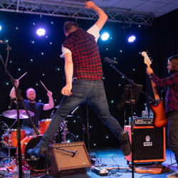 Darren and The Boss and The Beeston Street Band energetic on stage while playing hits from Bruce Springsteen. 